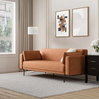 Orange sofa bed in a neutral living room