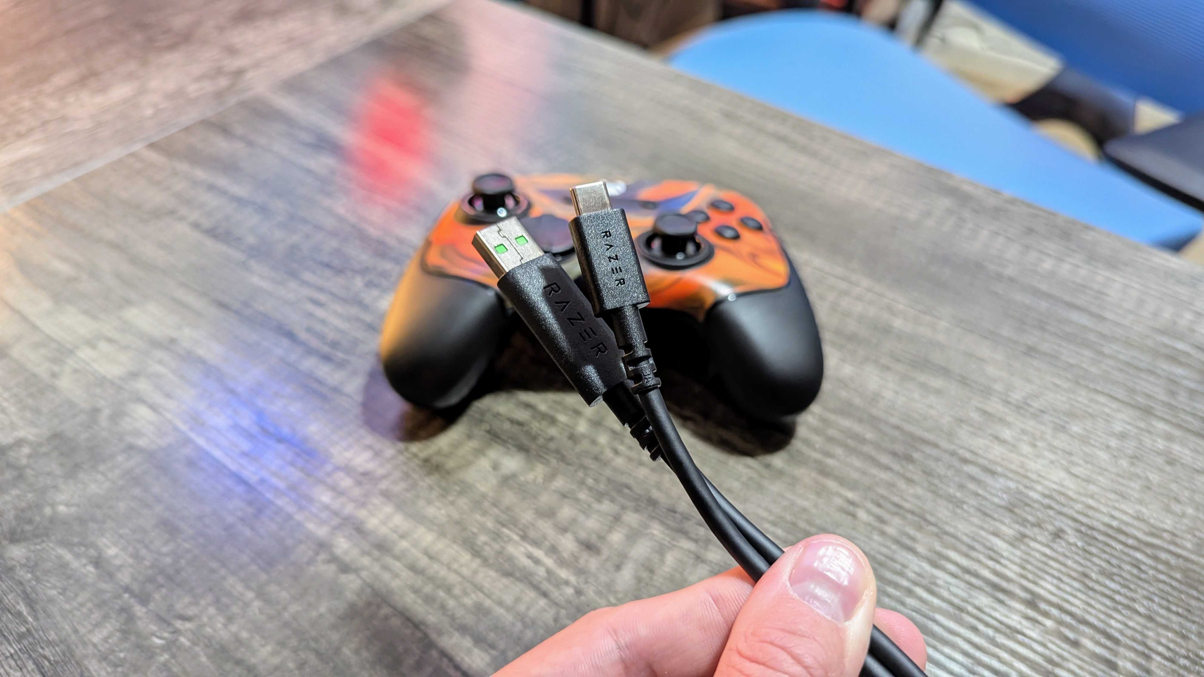 A USB Type-A to USB Type-C cable held in front of the Razer Wolverine V3 Tournament Edition.