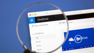 Microsoft OneDrive website under a magnifying glass. Microsoft OneDrive is a file hosting service.