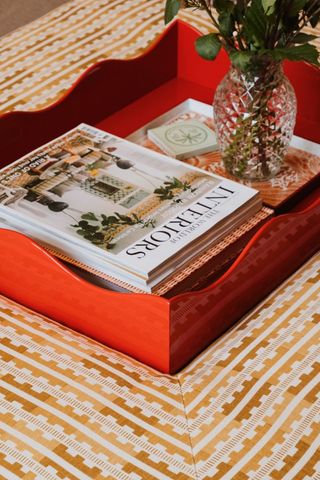 red wave tray with magazines on fabric ottoman