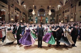 Men and women dance in traditional costumes at the Hunters' Ball in Vienna