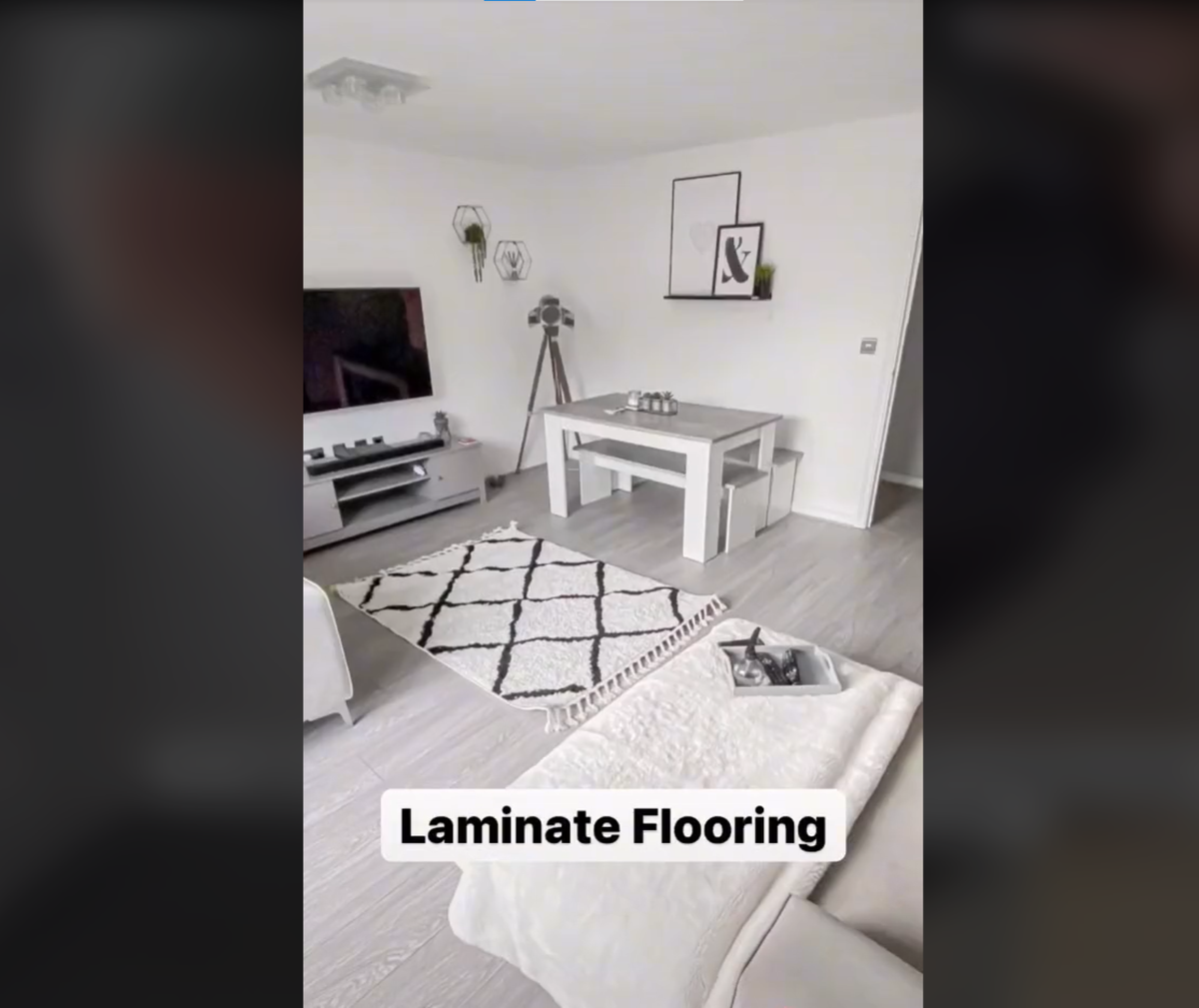 White DIY laminate flooring in living room with a small carpet lying on top