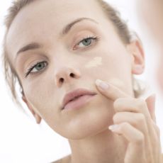 woman applying foundation to her skin