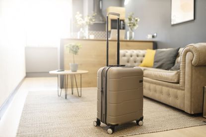 Modern suitcase placed in living room