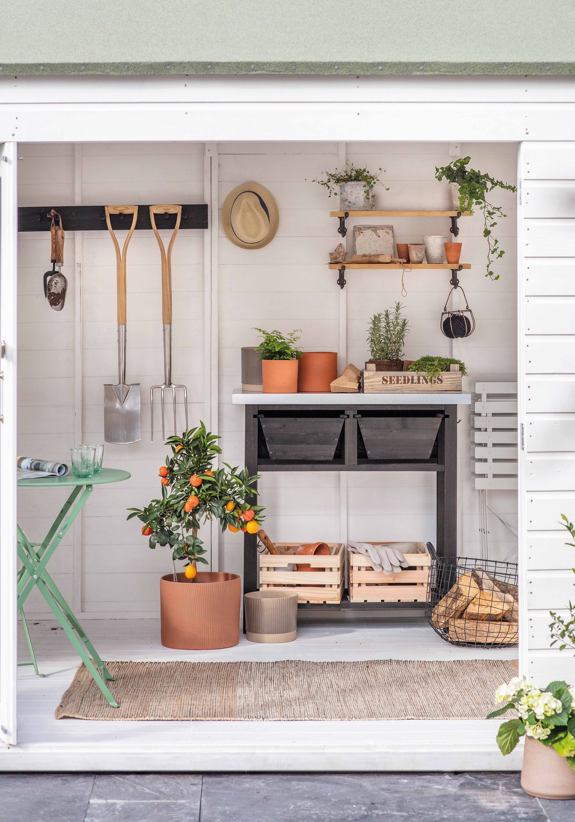 A white potting shed with potting bench