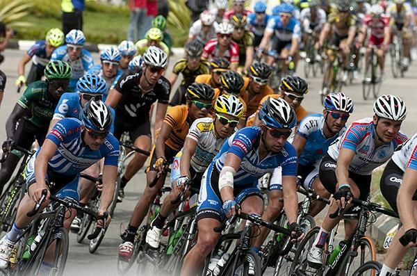 The peloton corner their way onto a stretch of road with a large group of riders around three minutes ahead.