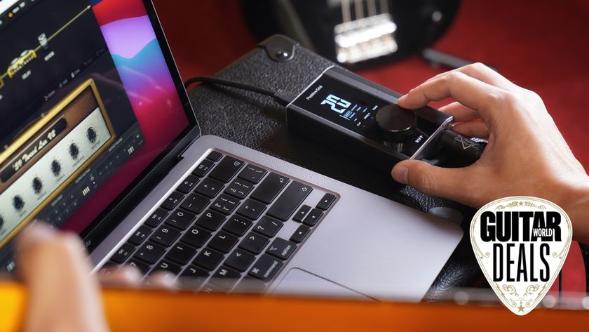 A man presses a button on a Positive Grid Riff audio interface