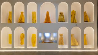 Gallery view of The Met’s Sleeping Beauties Reawakening Fashion, featuring a two-level display of yellow dresses