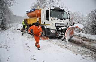 A snow plough receives assistance after coming off the road on February 18, 2022 in Balfron, Scotland