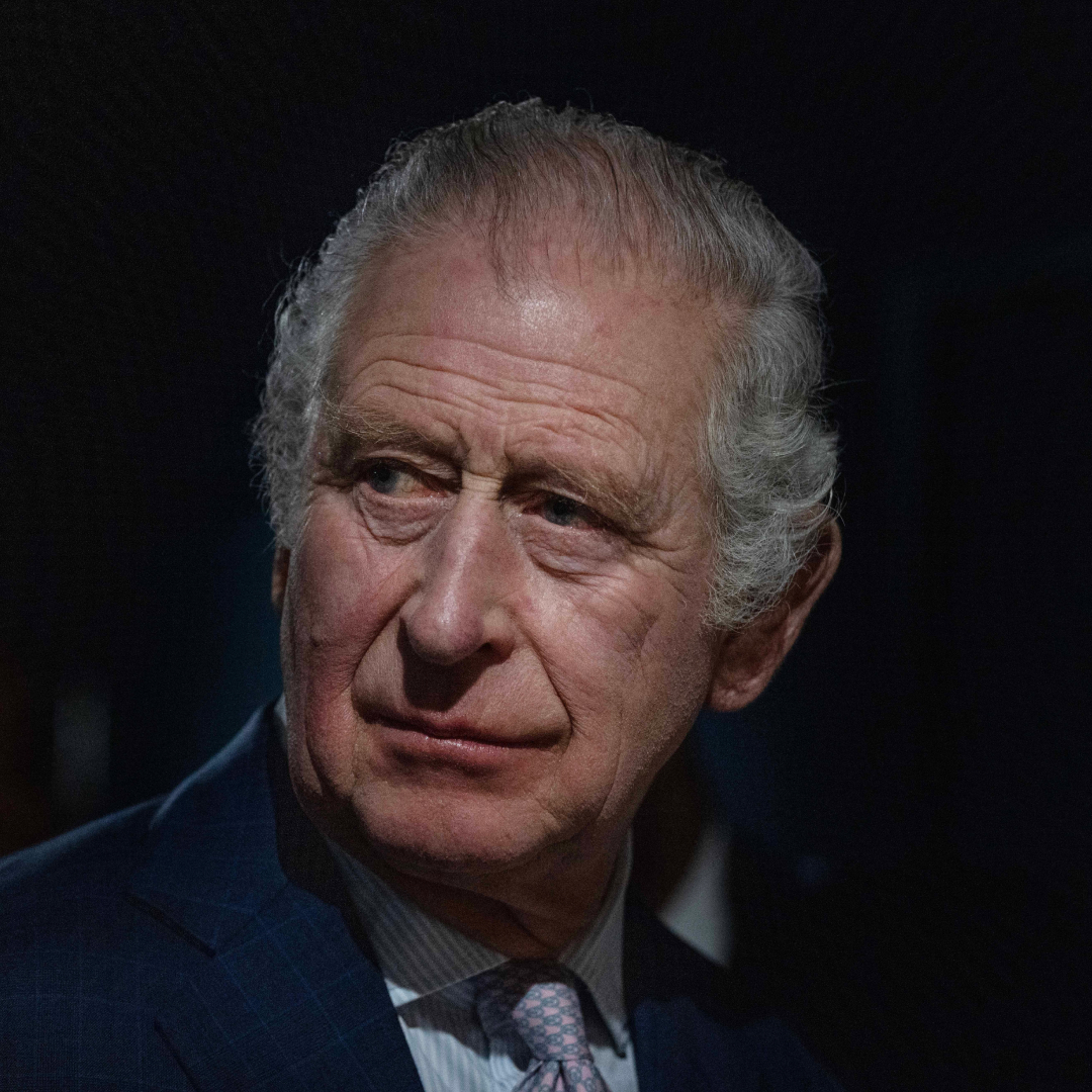 King Charles looks serious as he stares while wearing a suit