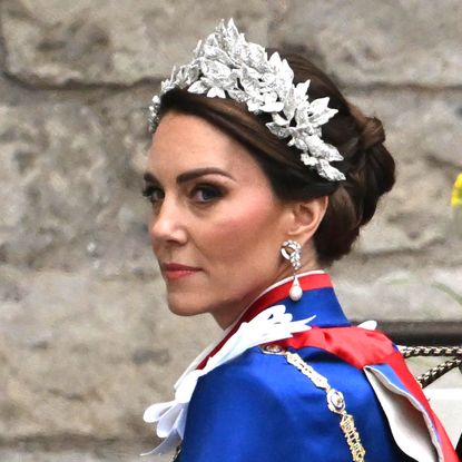 Kate Middleton wears a royal blue and red cloak and a glittering crown of leaves