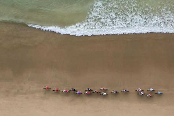 Cyclists ride on Dias beach during stage 5