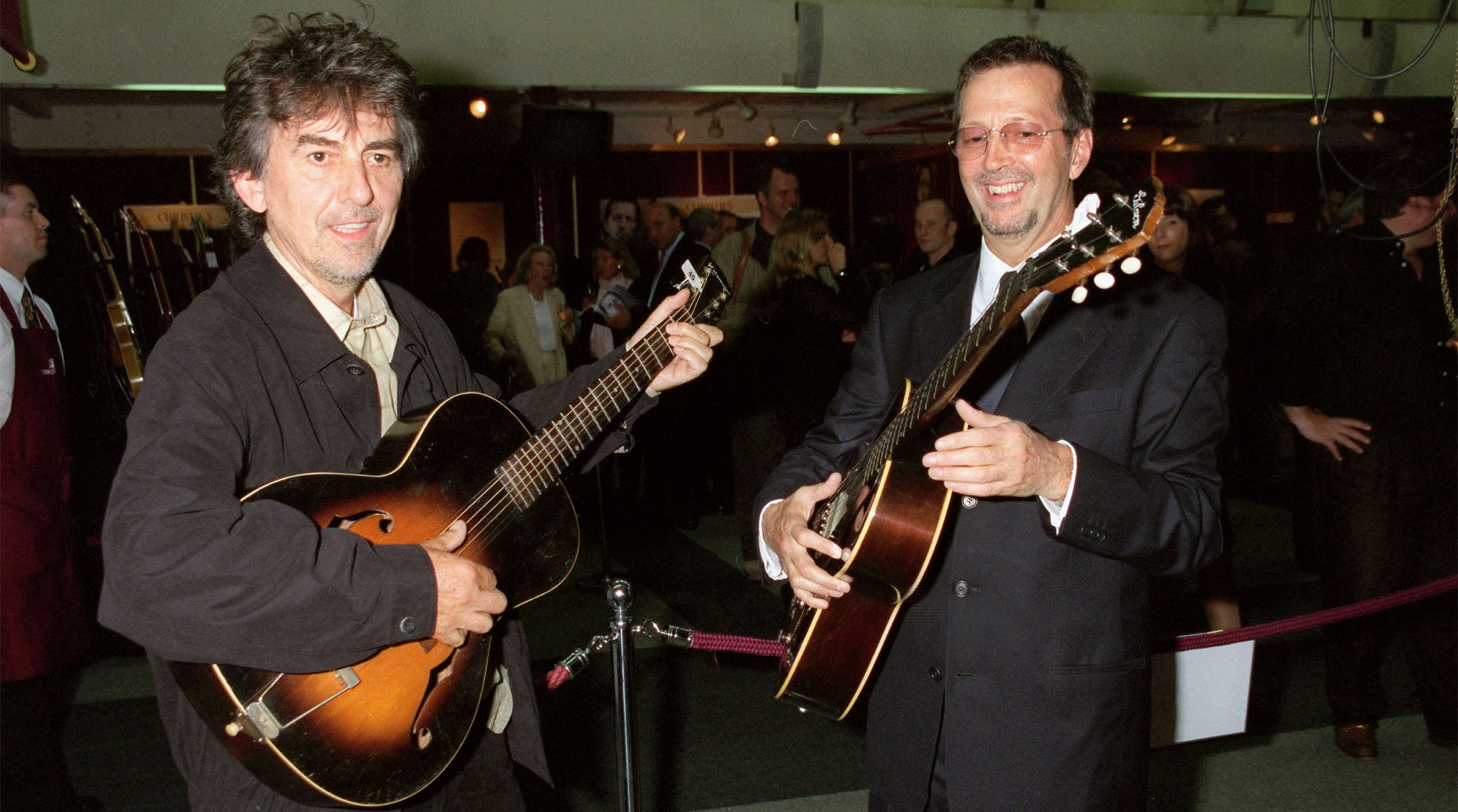 George Harrison (L) and Eric Clapton play some of the guitars on offer at Christie's Auction on June 24 at Christie's. The auction is to raise money for the Crossroad's Centre in Antigua, a foundation that treats alcoholics and drug abusers in the Caribbean, June 03, 1999 in New York.