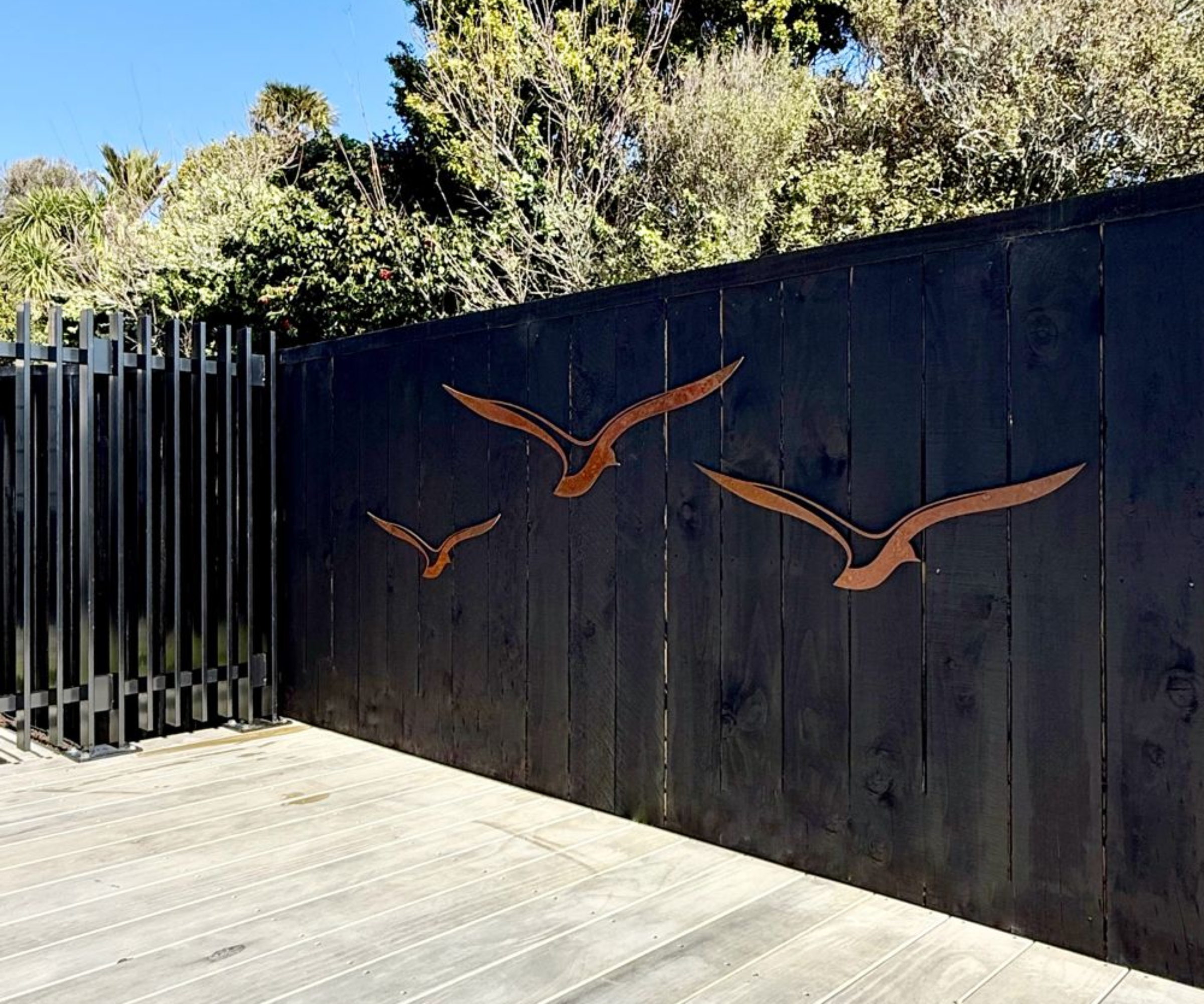 black painted fence with copper bird sculptures