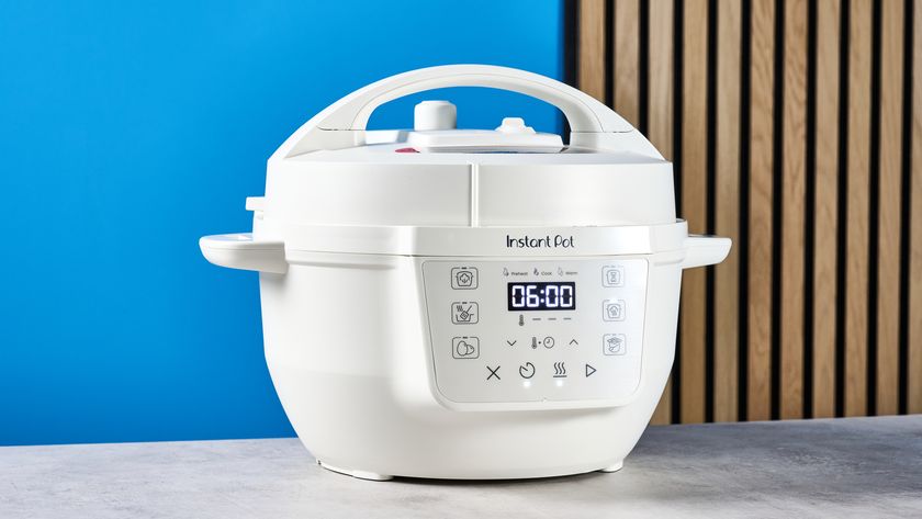 the instant pot rio mini / instant pot mini in white photographed against the blue tom's guide background showing its inner pot, accessories, and cooking programs