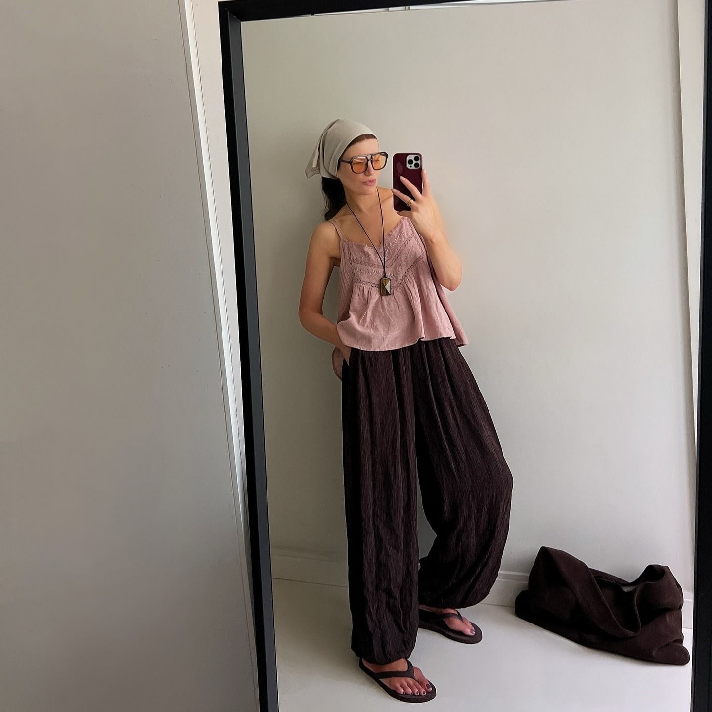 Influencer @honeybelleworld wears a pink cami top with chocolate brown sandals.