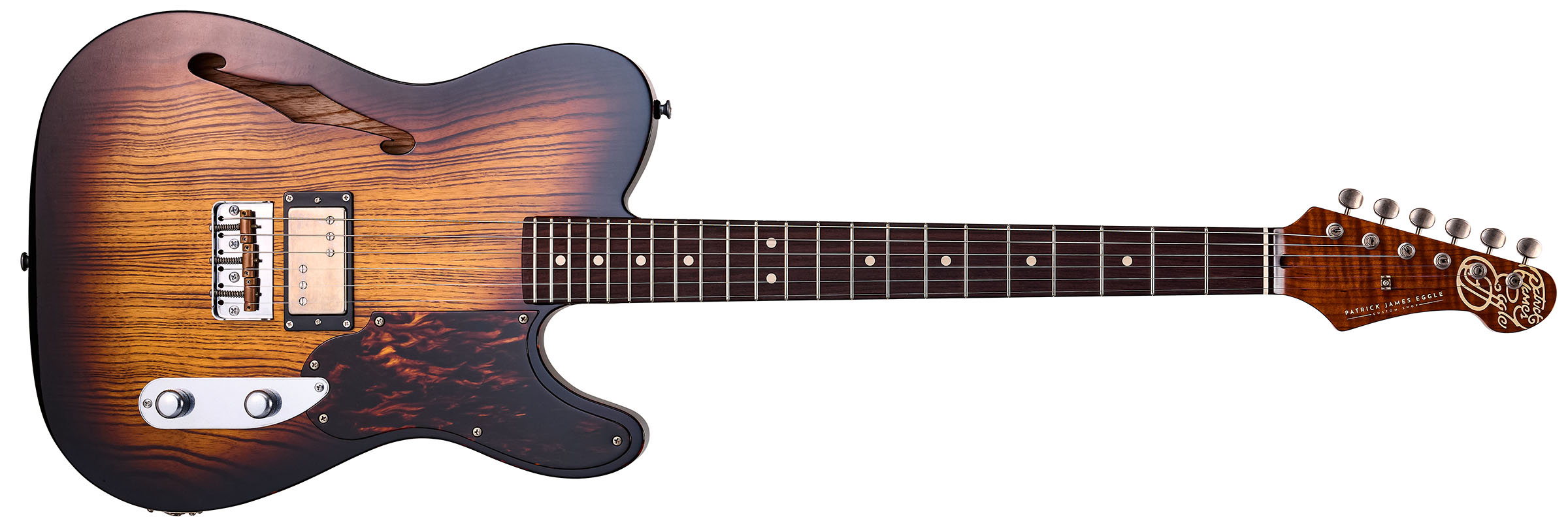 Patrick James Eggle Oz-t Cabronita Thinline; this semi-hollow T-style has a dark sunburst that reveals all the open grain, complementing the tortoiseshell pickguard, and is photographed here against a distressed floor, white and wooden backgrounds.