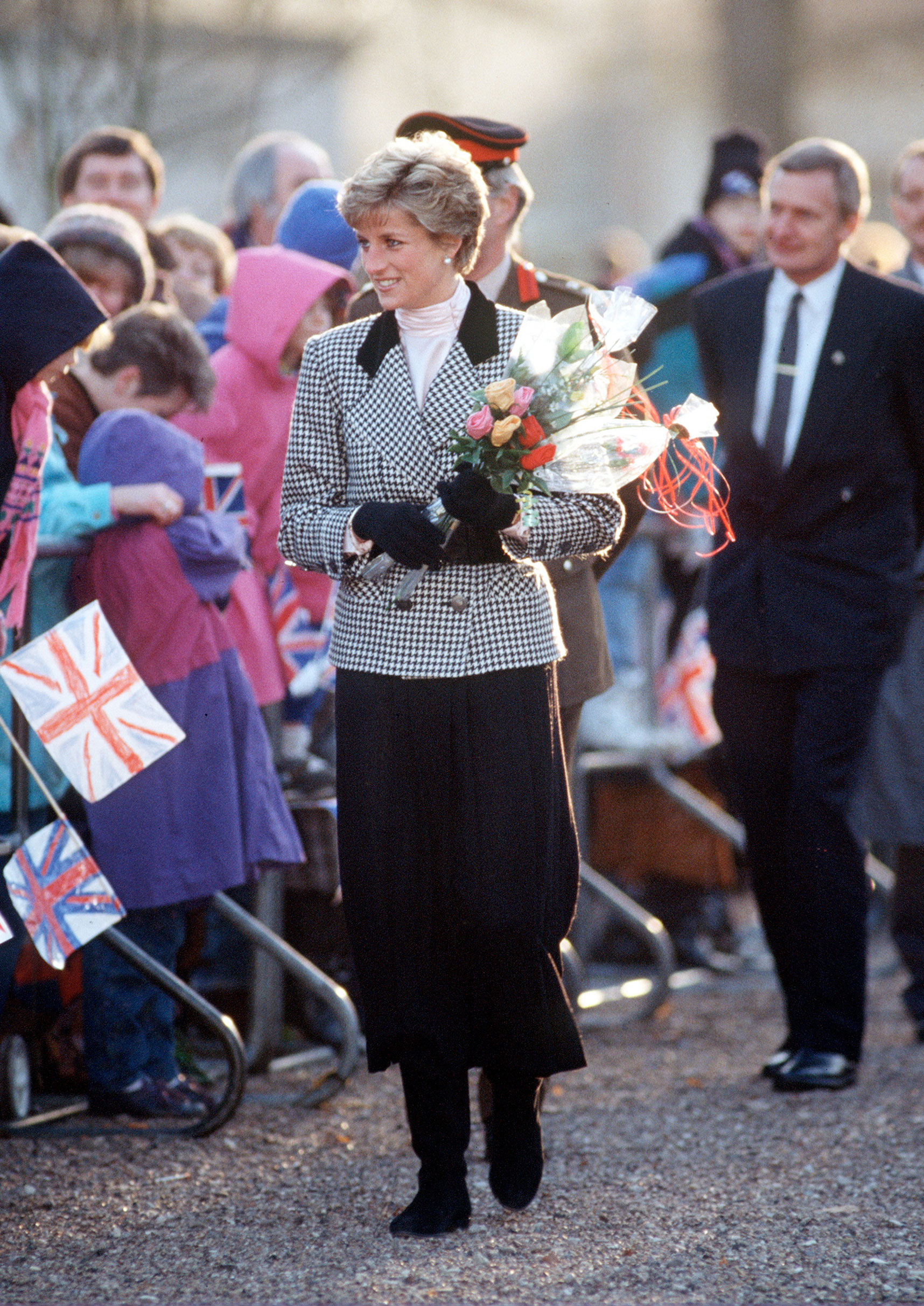 Princess Diana wears a midi skirt and knee-high boots