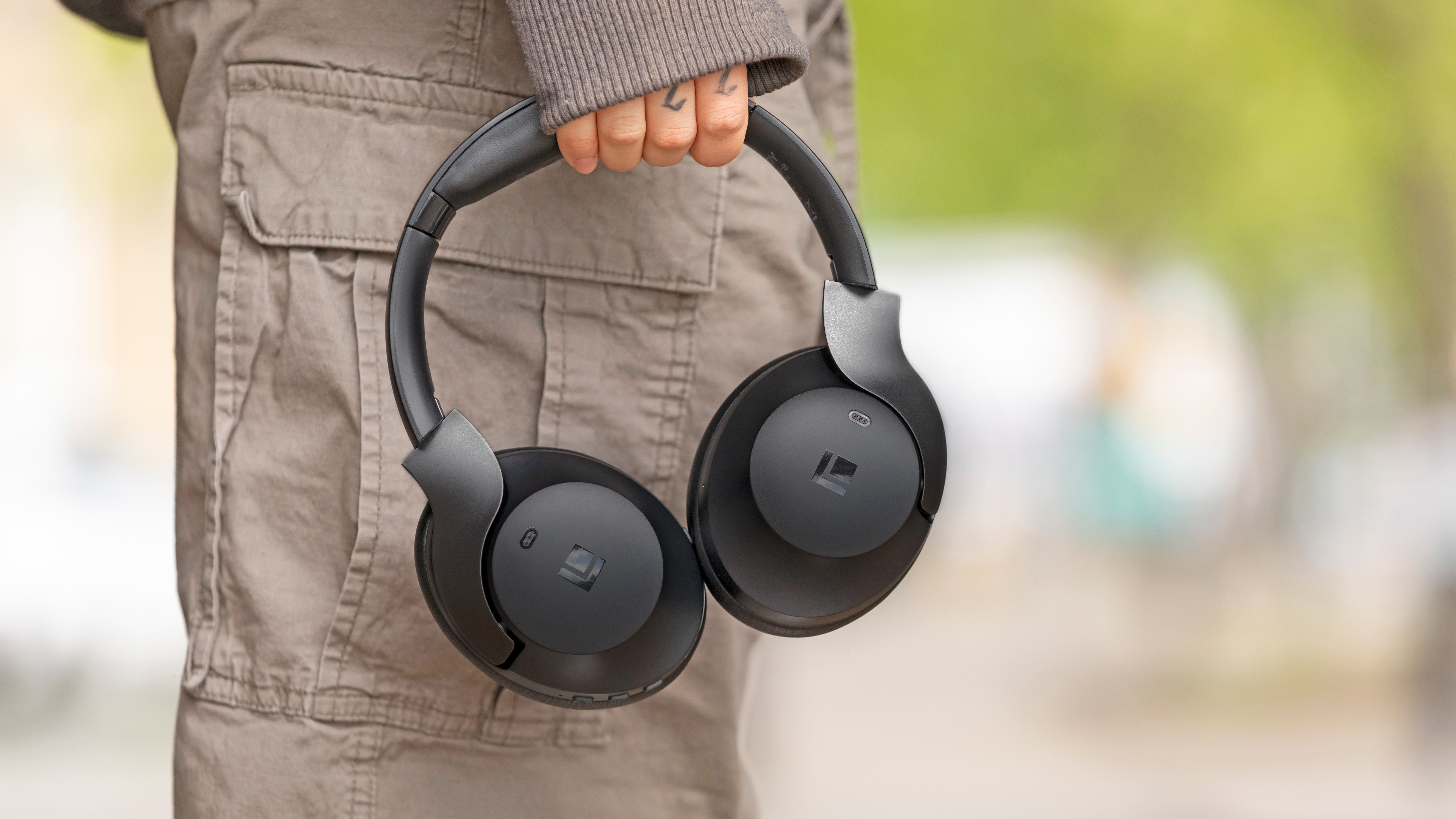 Lindy BNXe over-ear headphones in black held in the hand