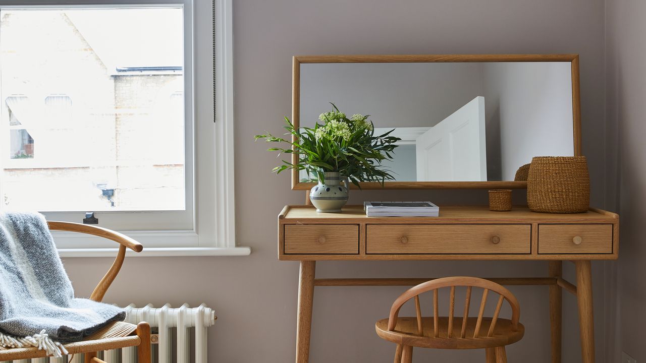 Blush pink bedroom with small wooden desk