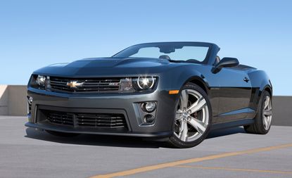 Daytime image, dark grey Chevrolet Camaro ZL1 Convertible parked in a car park space, yellow bay lines, blue sky