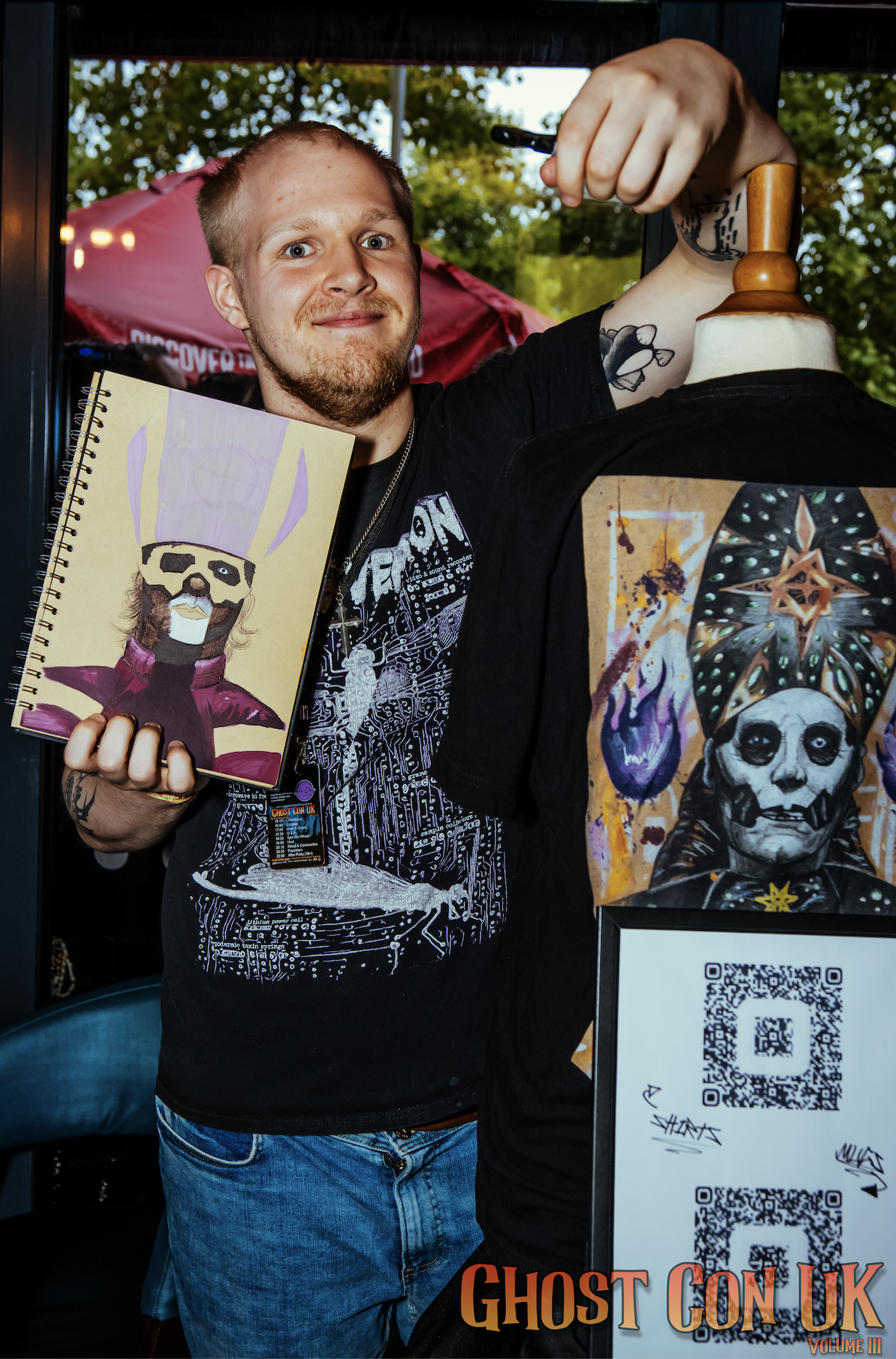 A stall vendor showing off some Papa Emeritus drawings