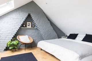loft conversion with sloping ceilings, exposed brick wall and double bed photographed by Chris Snook
