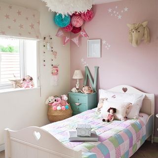 kids bedroom with decorating pompoms on ceilings and pink wall