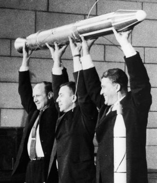 Members of the Explorer 1 team hoist a model of the satellite during a postlaunch news conference in 1958. From left: William Pickering, then-director of the Jet Propulsion Laboratory; James Van Allen, Explorer 1 principal investigator; and Wernher von Braun, chief of guided missile development operations for the Army Ballistic Missile Agency at Redstone Arsenal in Huntsville, Alabama.