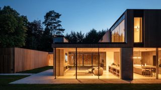 night time shot of exterior of contemporary passivhaus with large glass windows