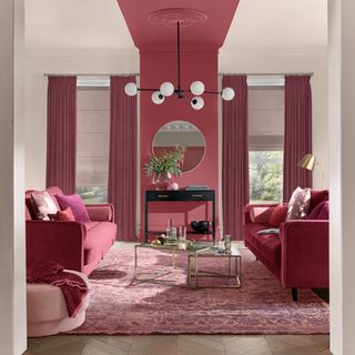 living room with feature panel in red paint and two red sofas either side
