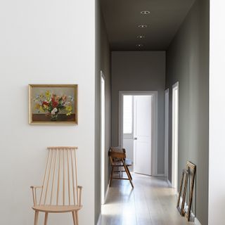 Little Greene Grey Moss used in a hallway space with a wooden chair and a piece of artwork