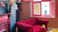 A pink and blue small living room with a pink couch