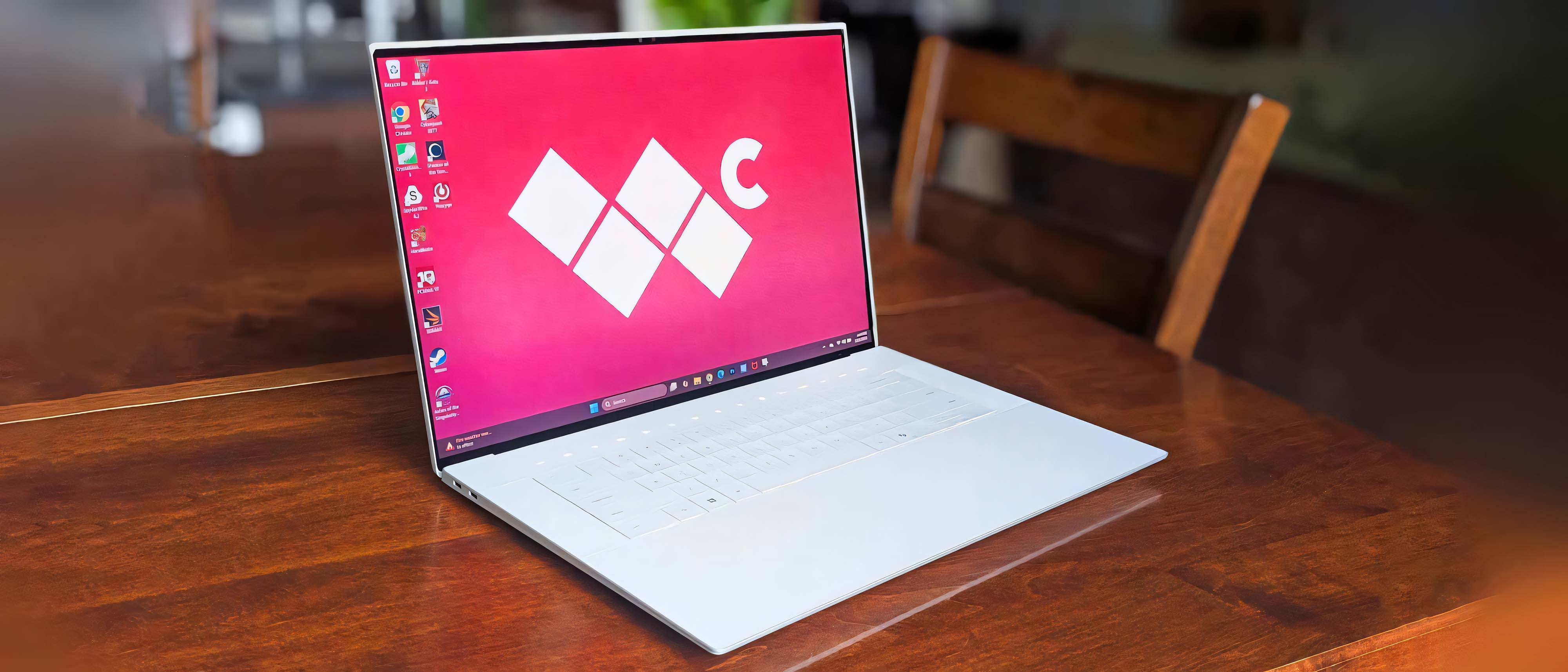 Dell 16 Premium laptop on a wooden table. The Windows Central logo is displayed on the laptop&#039;s background. 