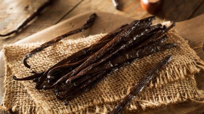 Vanilla pods on hessian on a wooden table