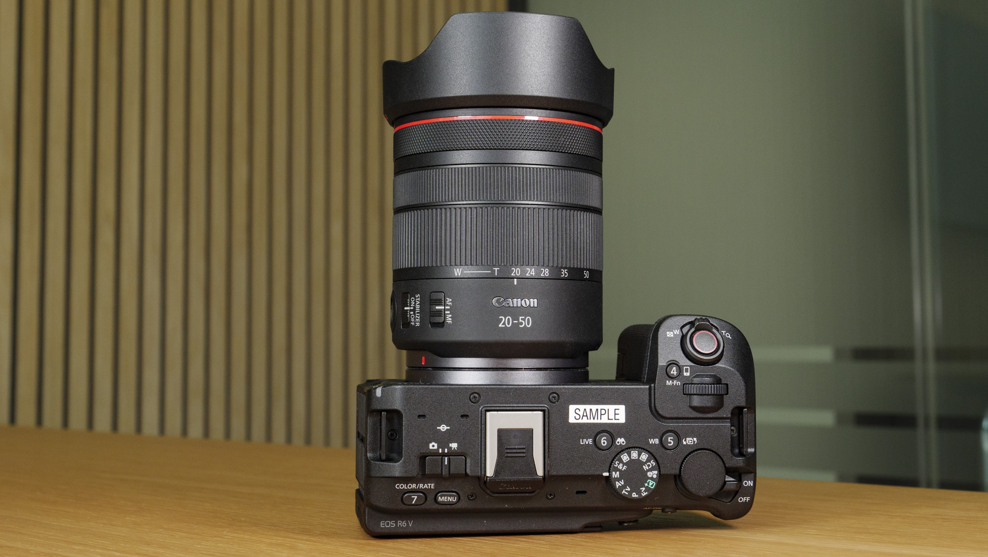 The Canon EOS R6 V on a wooden table with the 20-50mm F4 PZ lens attached