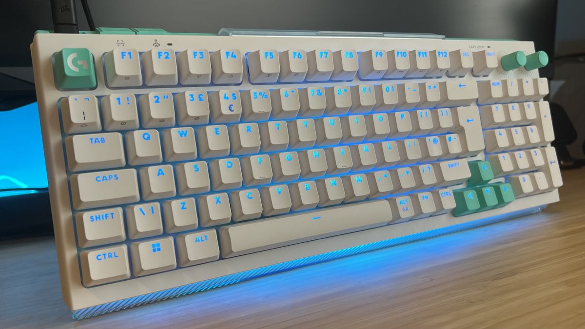 Logitech G512 X gaming keyboard with blue backlighting on a wooden desk