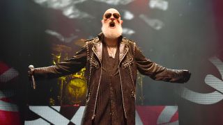 Rob Halford standing on stage with his arms outstretched