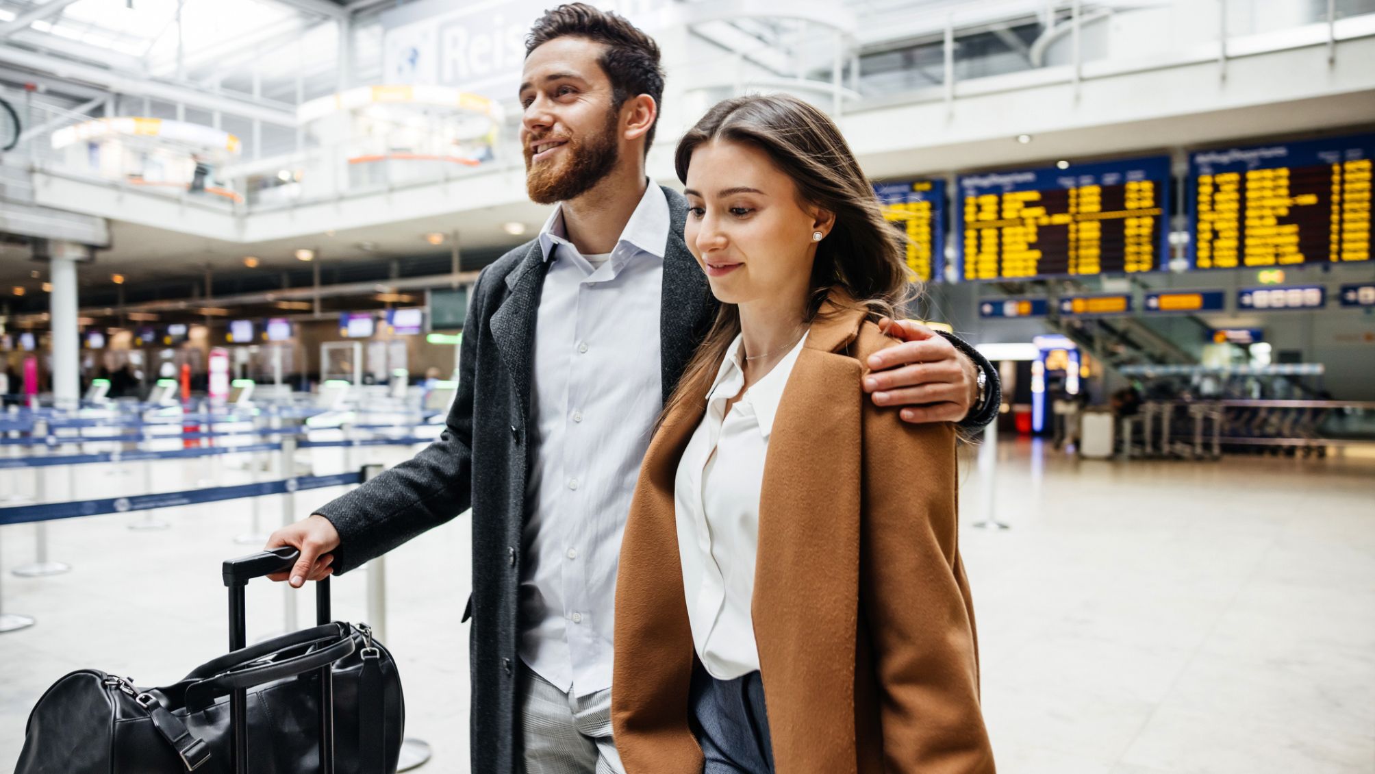 A couple walking through the airport to catch their flight. 