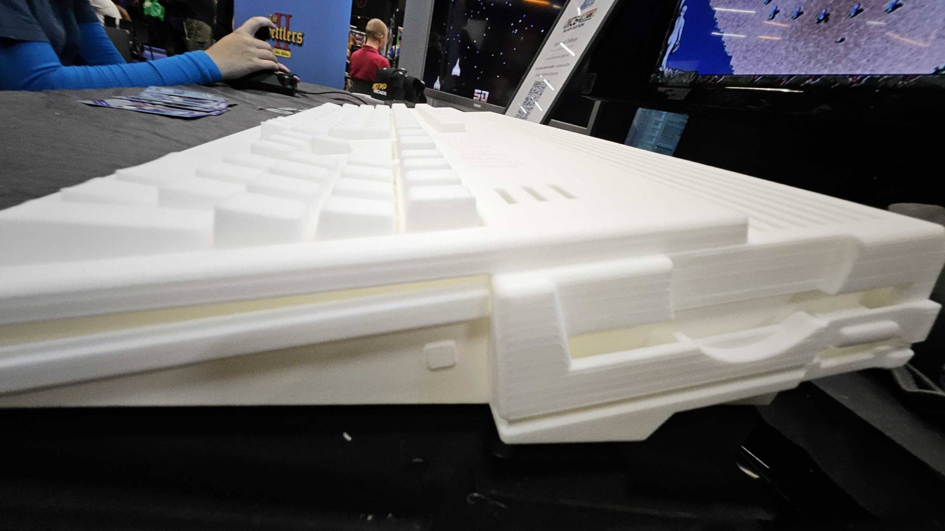 Close up of White Amiga A1200 prototype floppy drive slot on black table at Gamescom 2025.