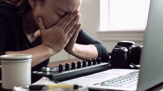 Woman feeling frustrated by her laptop whilst editing