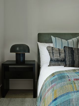 bedroom with upholstered bedhead and check throw
