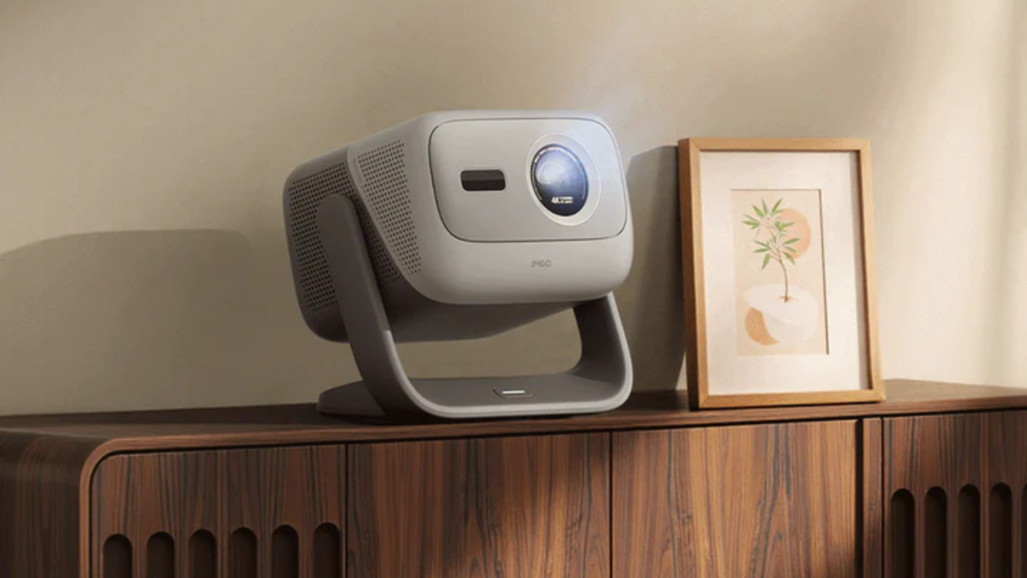 Promotional image of the JMGO N3 4K projector sitting on a wooden sideboard