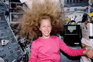 Marsha Ivins, STS-98 mission specialist, is photographed on the aft flight deck of the space shuttle Atlantis in February 2001