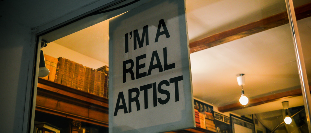 Sign in a shop window that reads &#039;I&#039;m a real artist&#039;