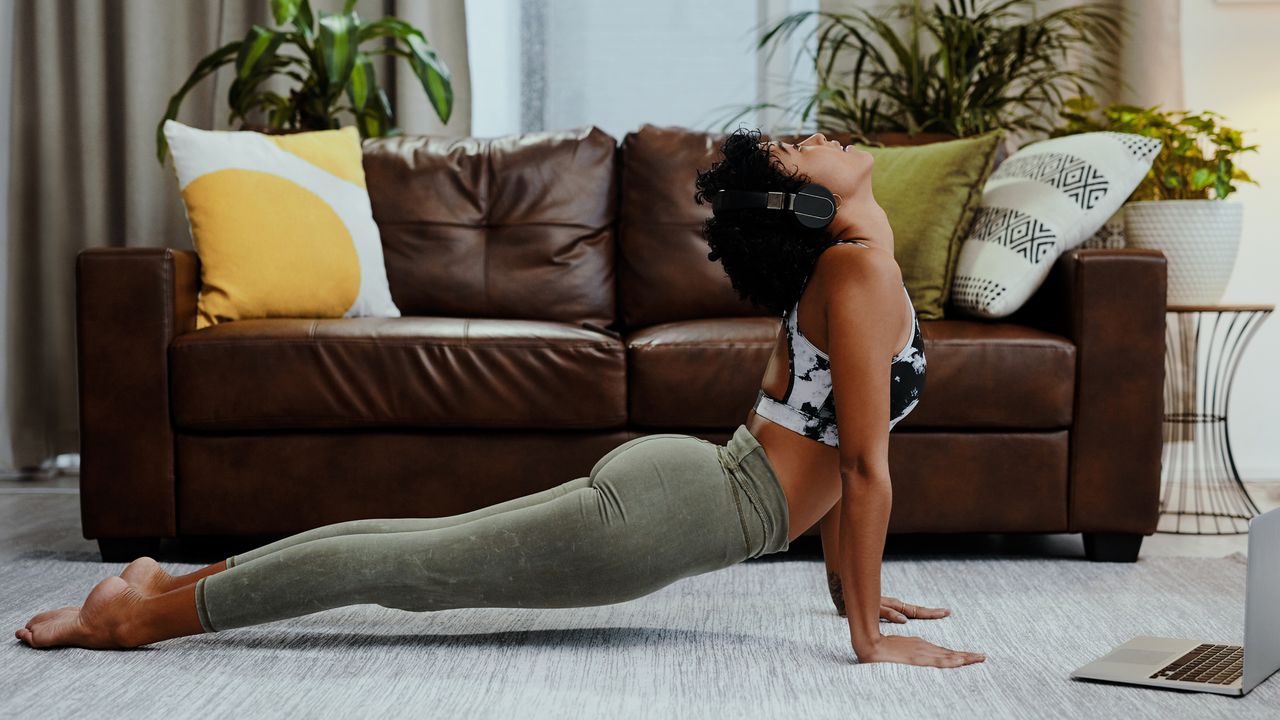 Person working out in a living room wearing headphones