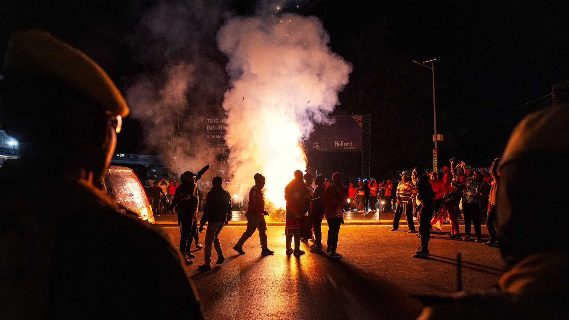 
                                Zambian police stands by as supporters of the President-elect Hakainde Hichilema celebrate his victory in the street in Lusaka, Zambia
                            