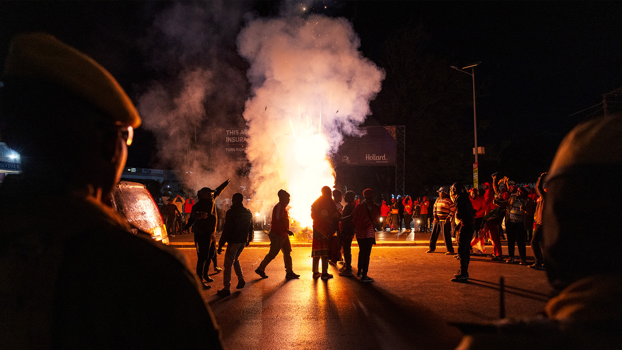 Zambian police stands by as supporters of the President-elect Hakainde Hichilema celebrate his victory in the street in Lusaka, Zambia