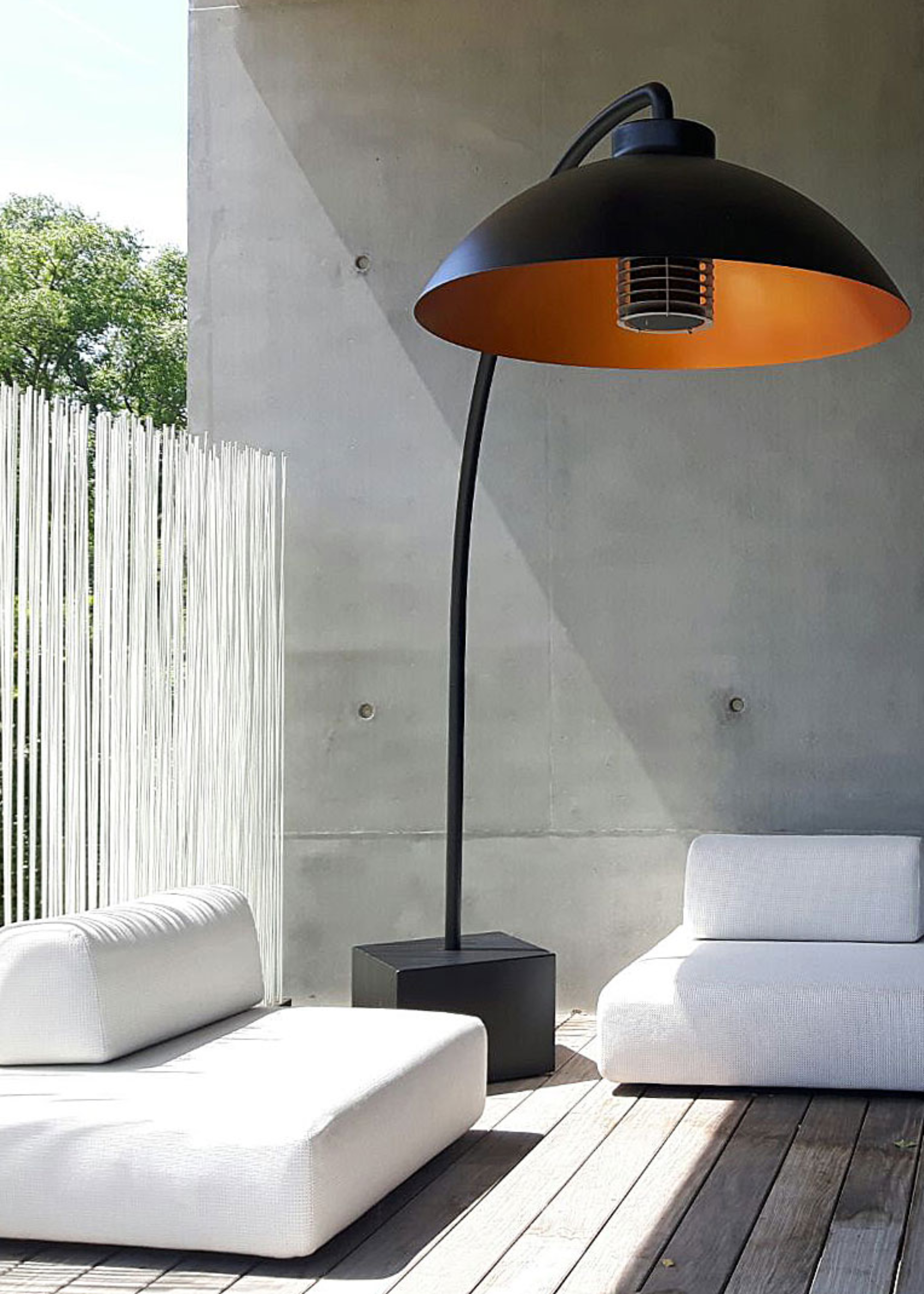 A patio heater with furniture places on either side of it in a backyard