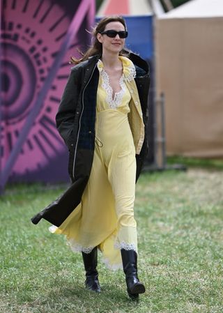 Alexa Chung wears a yellow dress and black boots to Glastonbury
